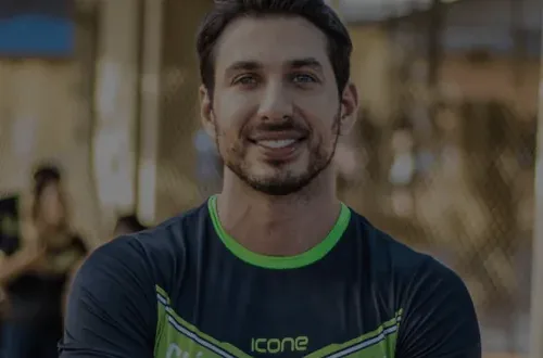 Dr. Mateus Lamari, de uniforme da Clínica Lamari, sorrindo durante um curso
