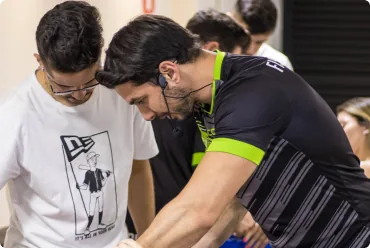 Dois participantes praticando palpação no antebraço durante curso na Clínica Lamari